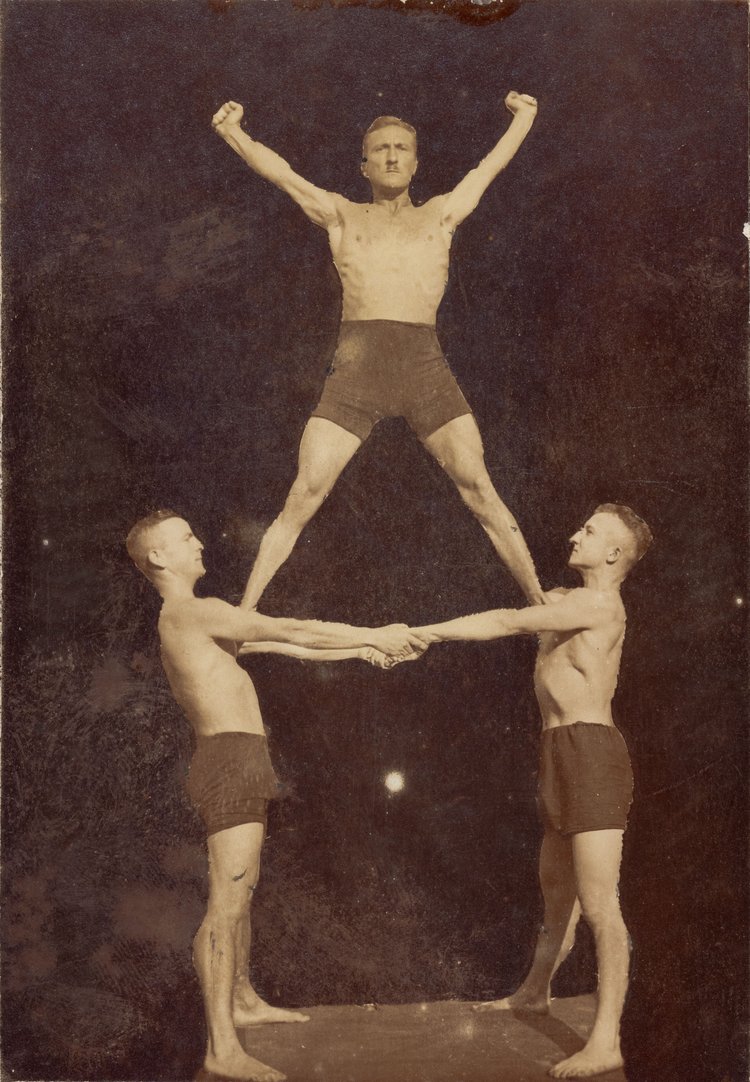 vintage photo (early 20th century) of three acrobats forming a simple human pyramid